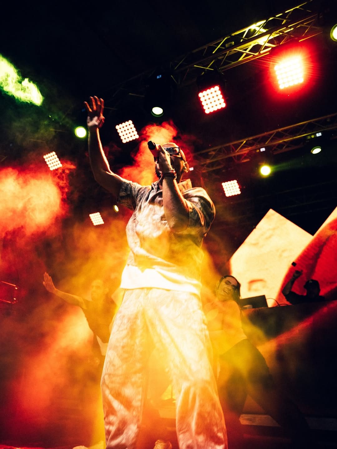 Fer Ariza en vivo entre humo naranja durante su show de merengue urbano